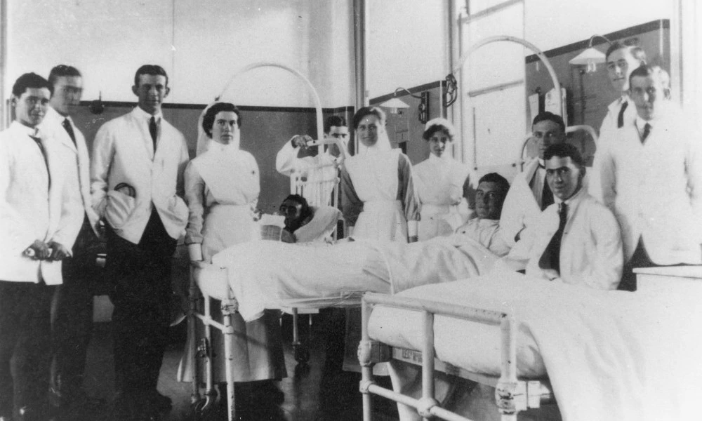 1920s ward scene of medical nurses by male patients' bedside