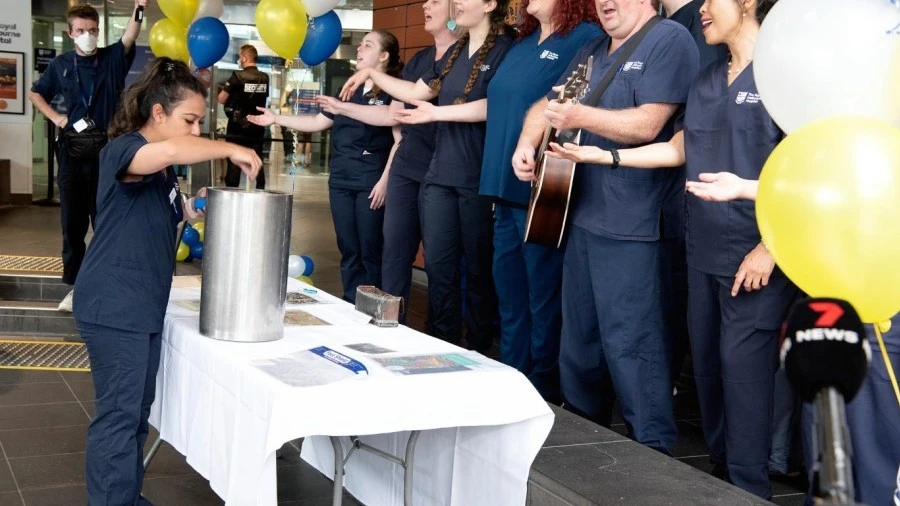 Staff adding items to time capsule for the RMH 175th birthday event