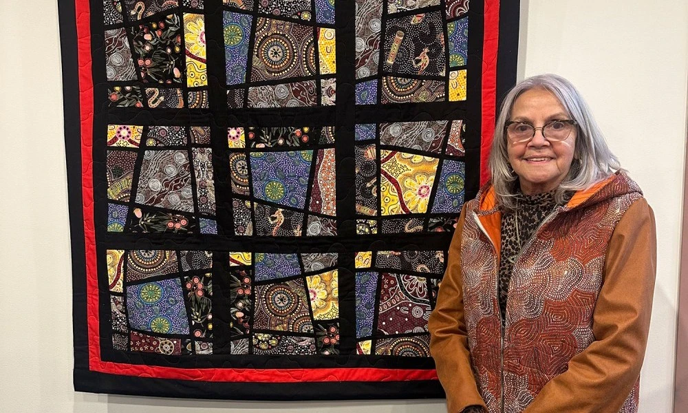 aunty-marlene-scerri-in-front-of-quilt-hung-on-display.jpg