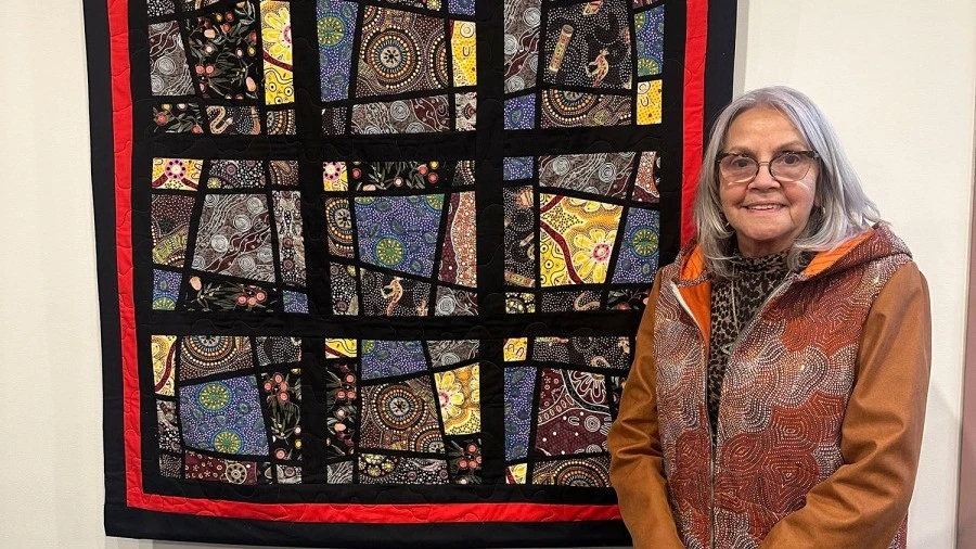 aunty-marlene-scerri-in-front-of-quilt-hung-on-display.jpg