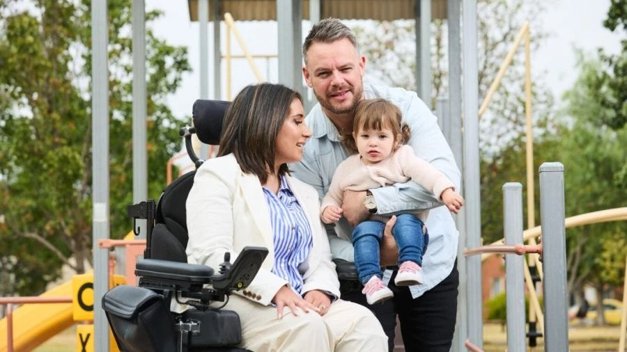Brianna seated at playground with her family