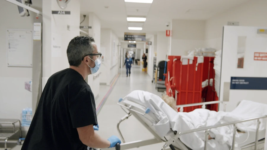 Clinical assistant moving patient from Emergency