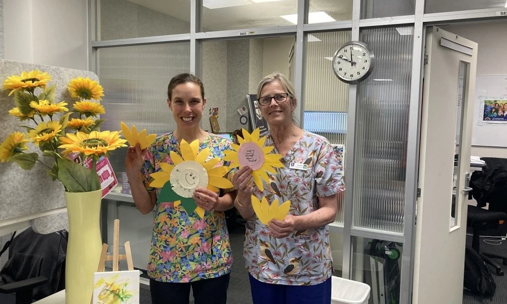 Disability Liaison Officers holding paper sunflowers