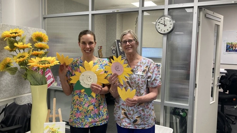 Disability Liaison Officers holding paper sunflowers