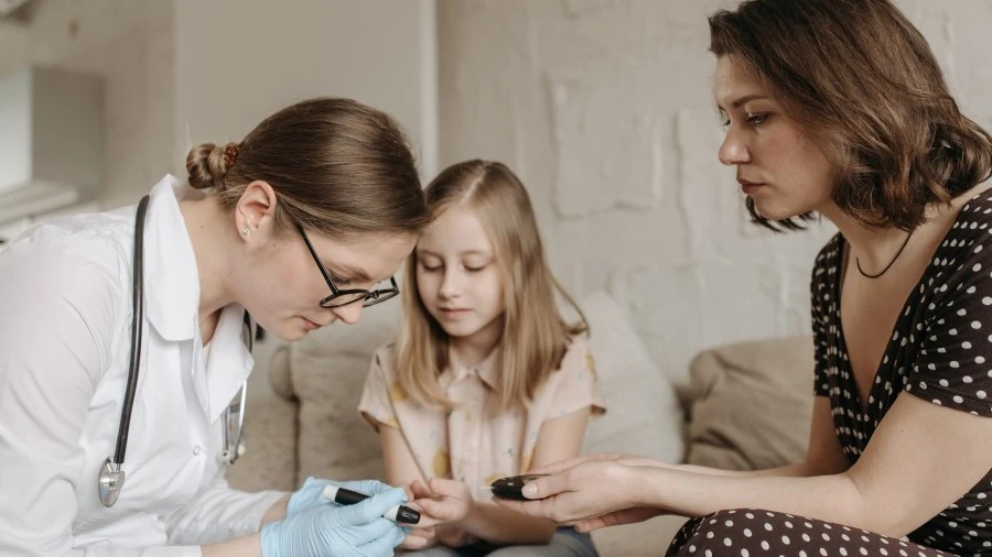 Doctor checking child's blood sugar