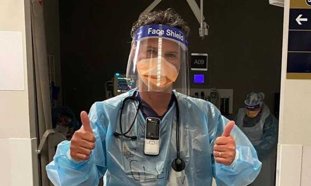 Dr Glenn Harrison in PPE giving thumbs up