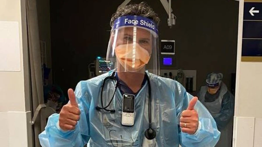 Dr Glenn Harrison in PPE giving thumbs up