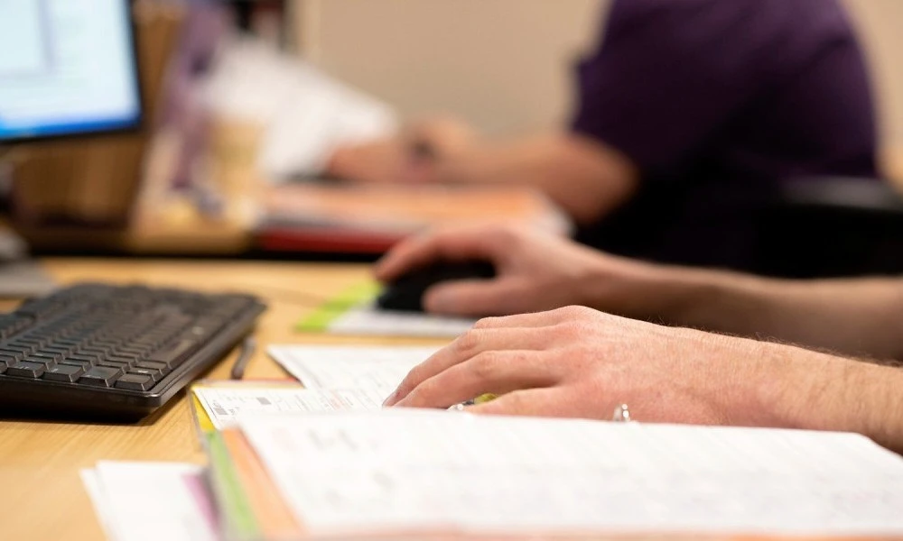 hands-using-mouse-and-keyboard-with-files-on-a-desk.jpg