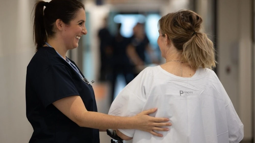 ICU physiotherapist supporting patient to walk
