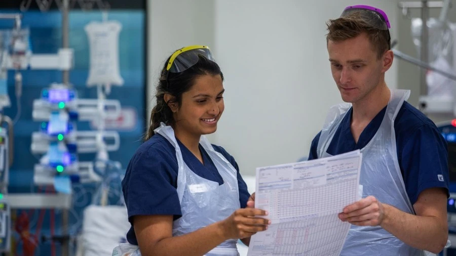Two ICU nurses looking at chart