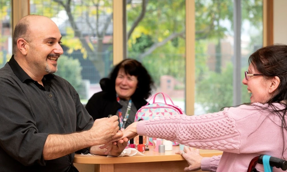 Man paints a resident’s nails at Cyril Jewell House