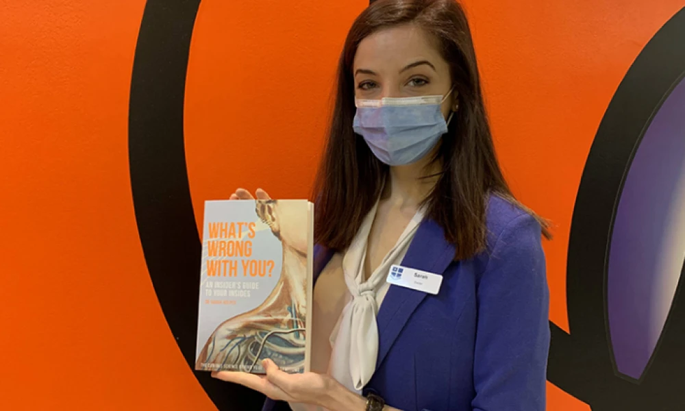 Neurology registrar Dr Sarah Holper with her book titled 'What's Wrong With You? An Insider's Guide To Your Insides'