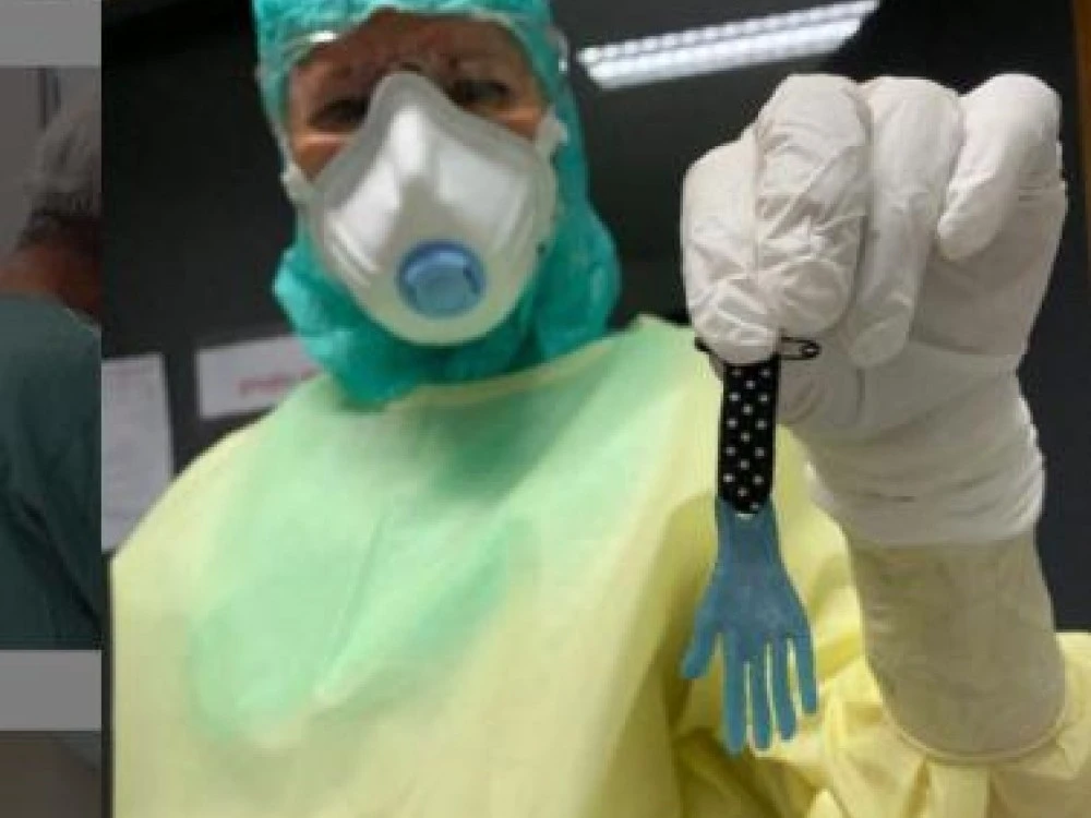 Doctor in full PPE with a hand medal