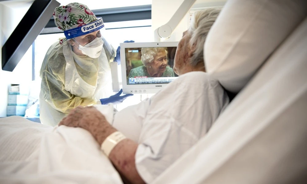 Nurse with a patient in bed on a ward