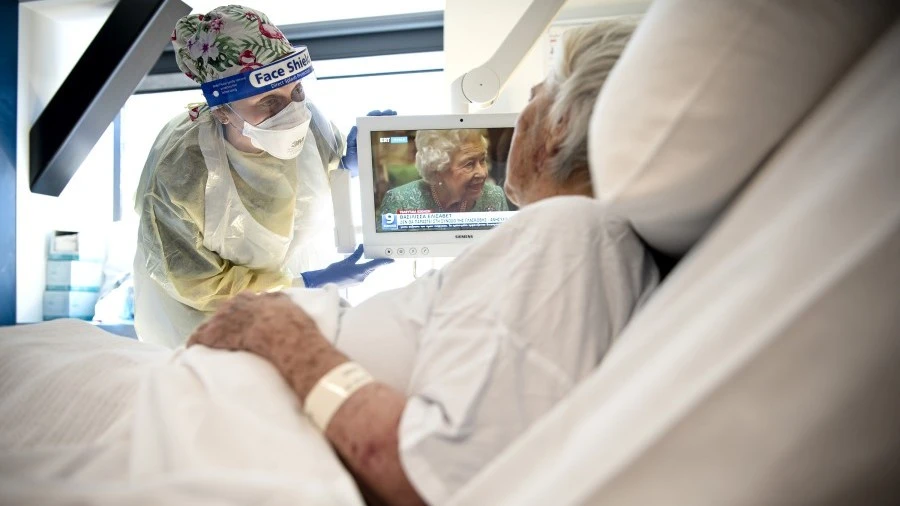 Nurse with a patient in bed on a ward