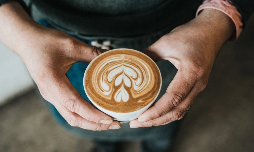 Person holding a takeaway coffee