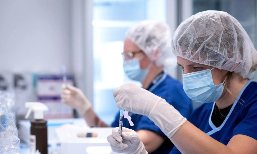 Pharmacists draws precise vaccine dose from vial