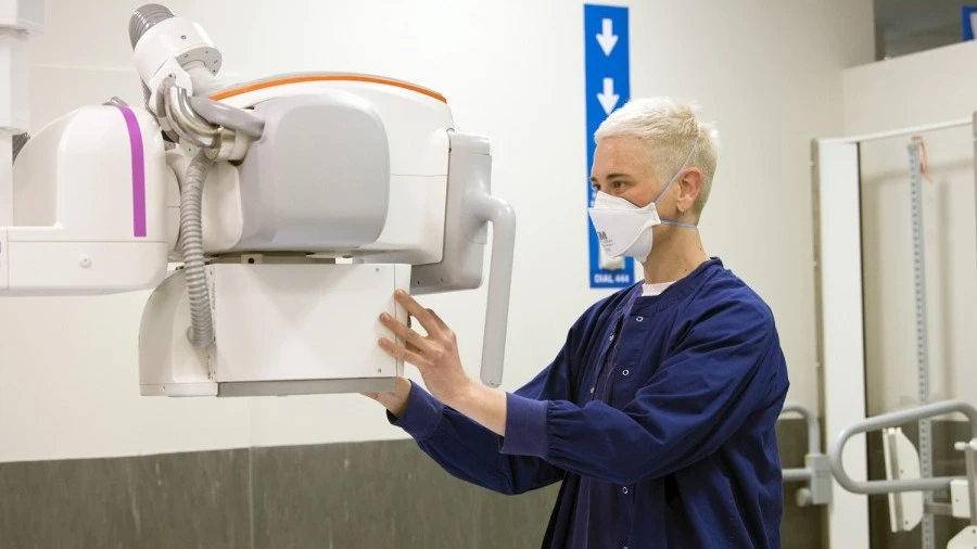 Radiology staff member operating x-ray machine