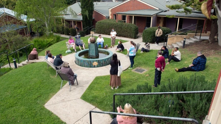 Residents and staff sit around fountain at Norfolk Terrace Community Care Unit (CCU)
