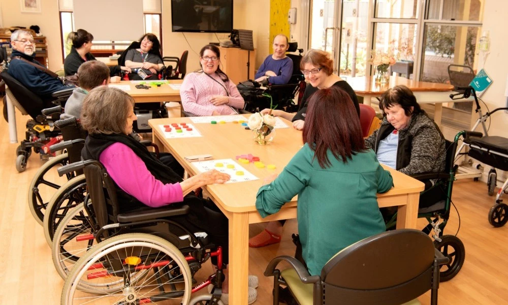 Residents playing numbers game around a table at Cyril Jewell House