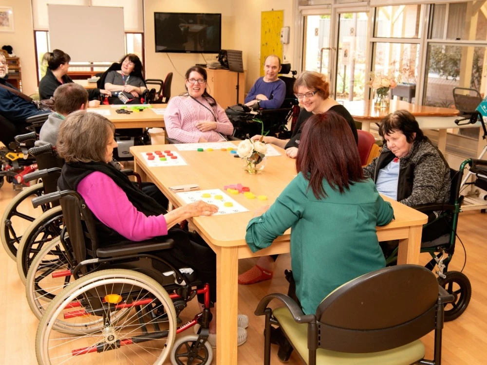Residents playing numbers game around a table at Cyril Jewell House