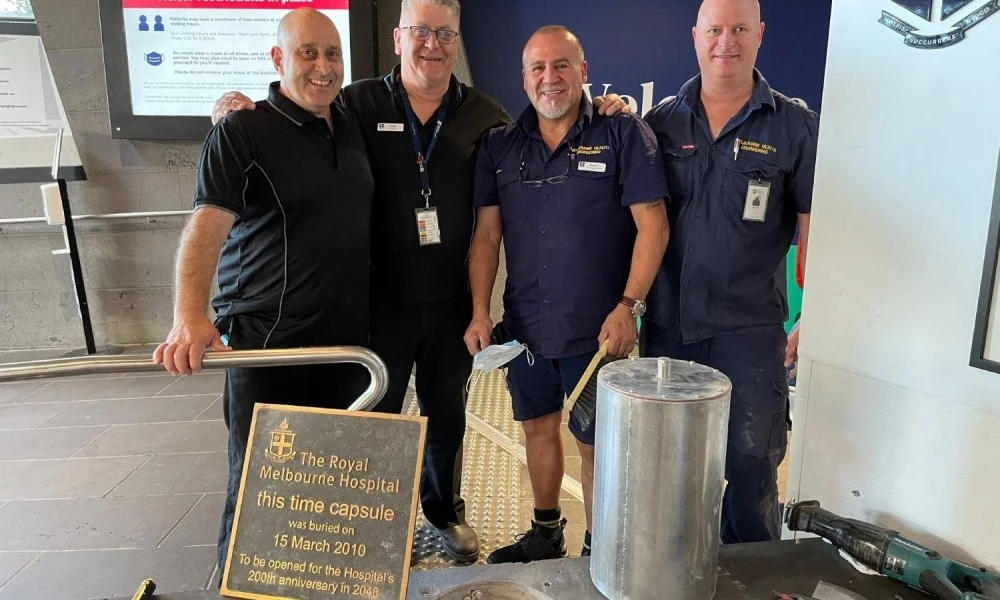Team of engineers with the time capsule and plaque in 2023