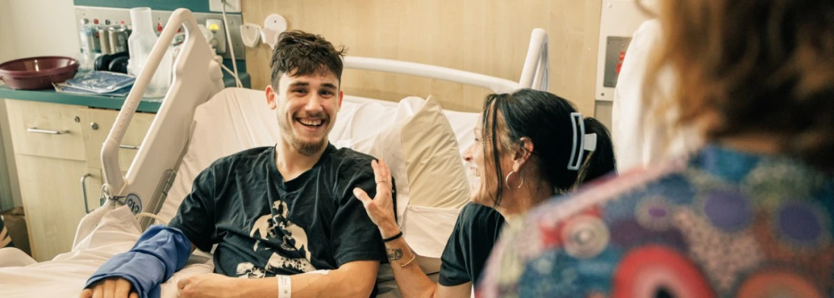smiling-patient-with-arm-cast-in-hospital-bed.jpg