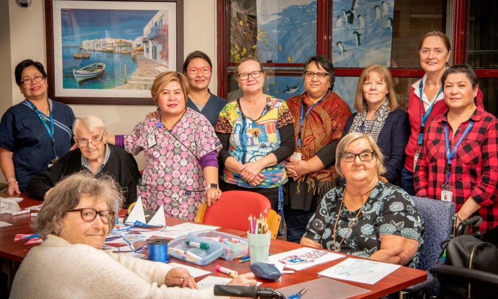 Staff and residents around arts and crafts table at Boyne Russell House
