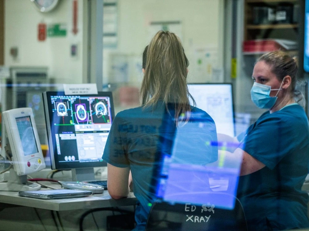 staff-in-face-masks-and-scrubs-at-computer.jpg