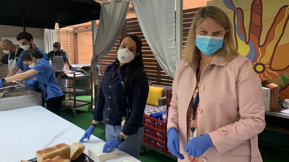 Two staff serving lunch in the garden