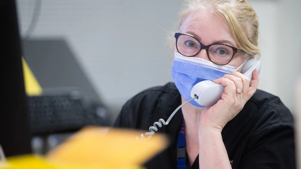 staff-member-in-mask-on-phone.jpg