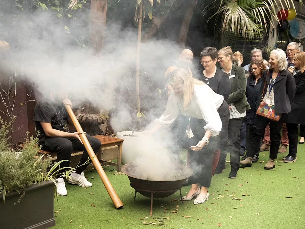 Staff participating in smoking ceremony for NAIDOC week 2023