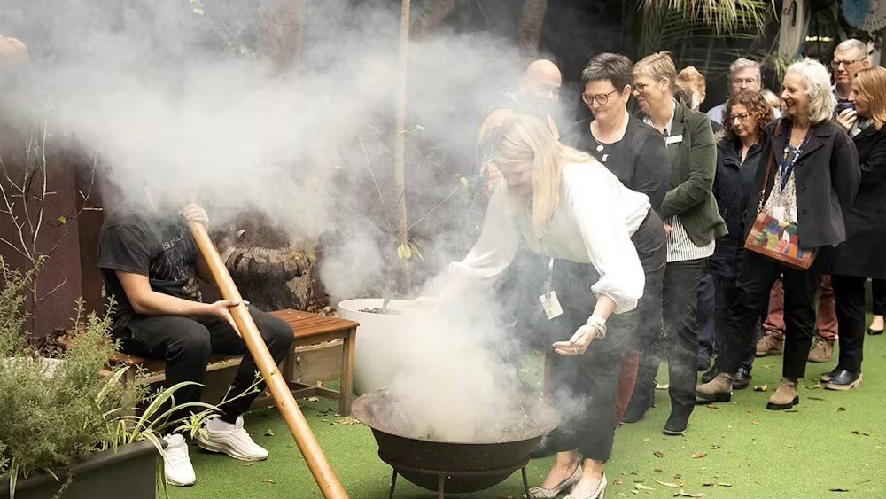 Staff participating in smoking ceremony for NAIDOC week 2023