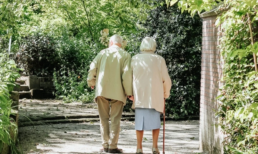 Two older people walking outside