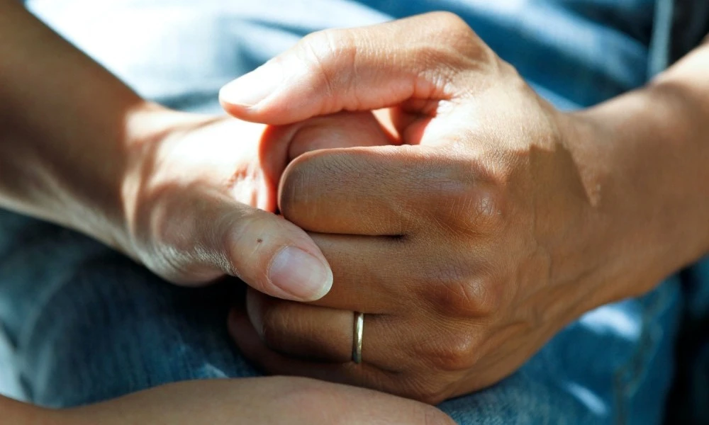 Two people holding hands firmly