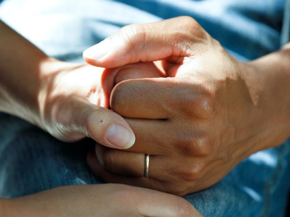Two people holding hands firmly