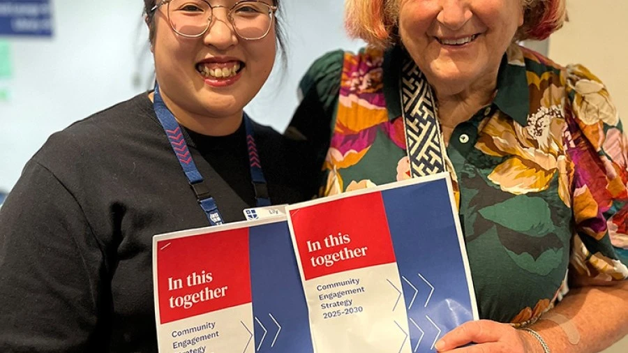 Two women hold the new RMH Community Engagement Strategy