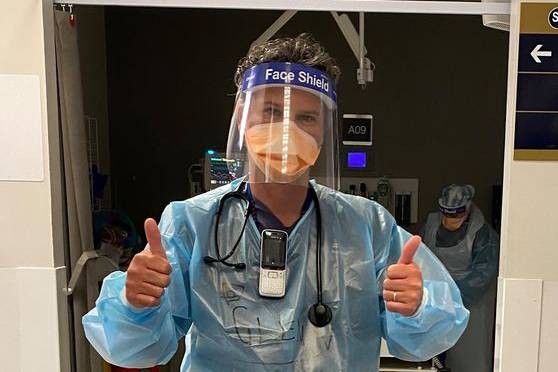 Dr Glenn Harrison in PPE giving thumbs up