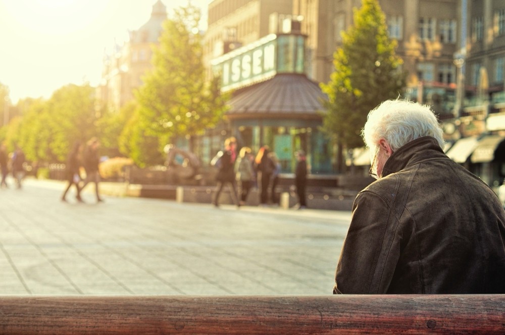 Older person sitting on park bench