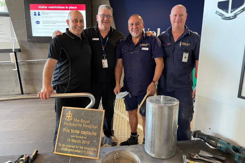 Team of engineers with the time capsule and plaque in 2023