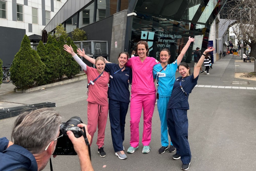 Staff in scrubs being photographed outside the RMH Parkville main entrance